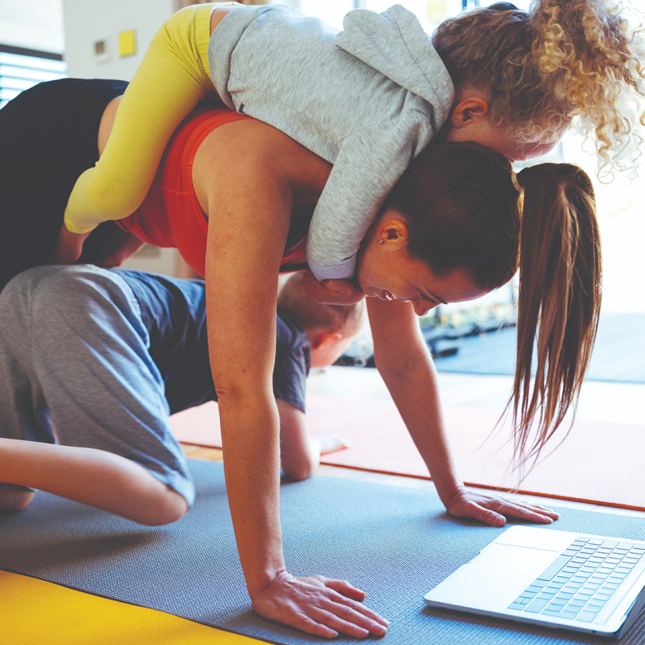 A mother dos yoga with her two children
